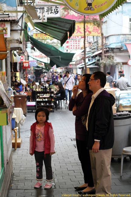 A family ponders the menu of a local fruit juice stand